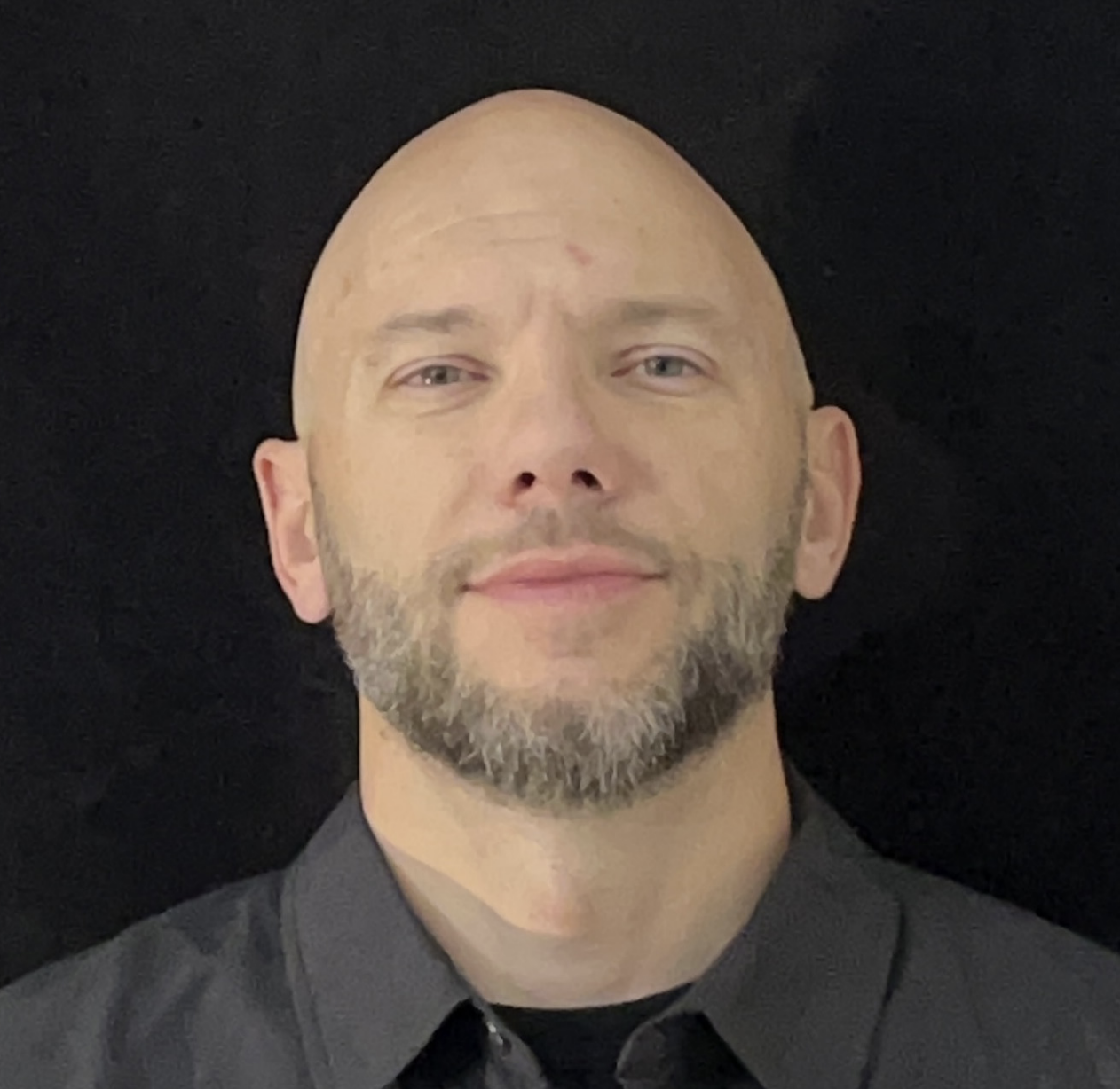 Portrait of Tim, Information Technology lead at Autism Acceptance World. Clean studio headshot, dark background, professional dark shirt.